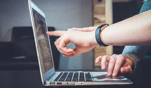 Two people looking at a laptop.